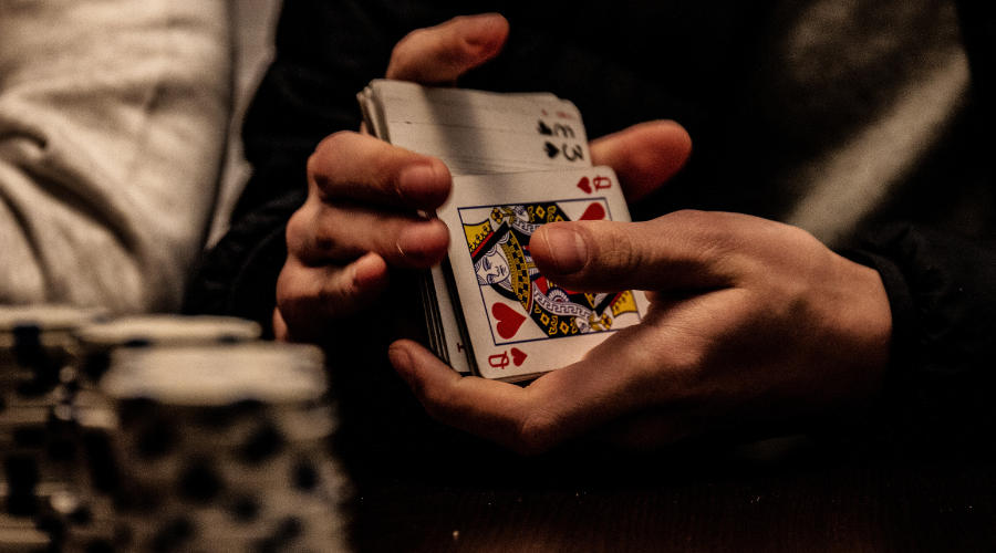 Hands holding playing cards during gambling